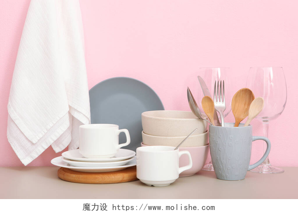 粉色背景上的桌子上的一套餐具桌子上的一套餐具。厨房器皿中简约主义风格的构图.